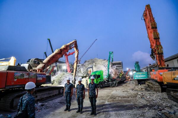 Heavy machineries are employed to clear the huge pile of concrete from the site of an under-construction high-rise building that collapsed on Friday after an earthquake in Bangkok, Thailand, Tuesday, April 1, 2025. (AP Photo/Wason Wanichakorn)