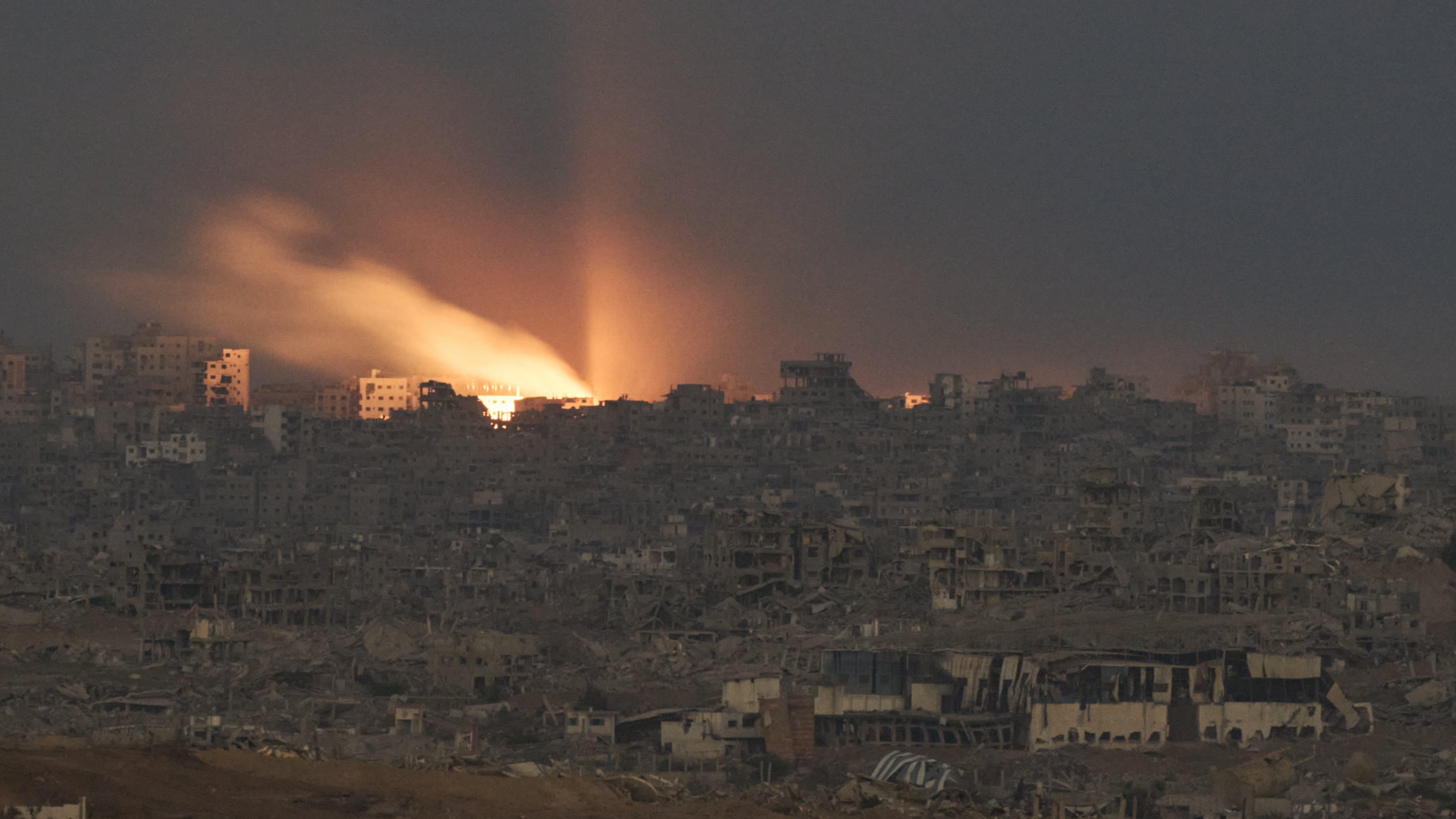 A fire erupts amid buildings destroyed during Israeli ground and air operations, following an Israeli military strike in the northern Gaza Strip, as seen from southern Israel, Monday, Oct. 6, 2025. (AP Photo/Leo Correa)