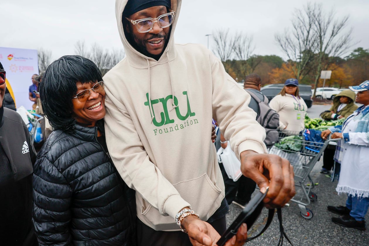 American rapper and actor 2 Chainz takes a selfie with Rachel Fortson of Decatur during the “Greens and Things" Thanksgiving giveaway event on Tuesday, Nov. 24, 2025. 2 Chainz teamed up with Walmart to help 150 families through the food giveaway in College Park. (Miguel Martinez/AJC)