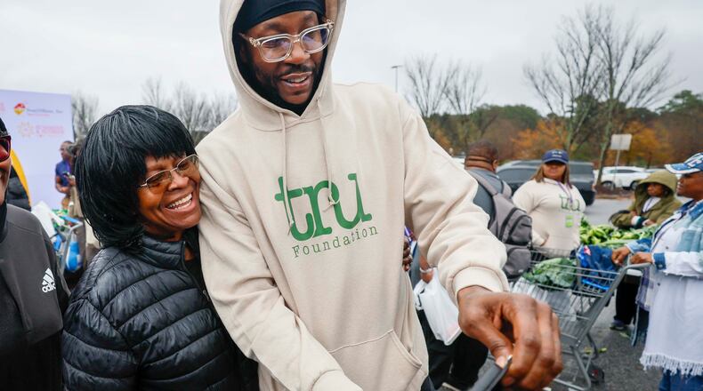 American rapper and actor 2 Chainz takes a selfie with Rachel Fortson of Decatur during the “Greens and Things" Thanksgiving giveaway event on Tuesday, Nov. 24, 2025. 2 Chainz teamed up with Walmart to help 150 families through the food giveaway in College Park. (Miguel Martinez/AJC)