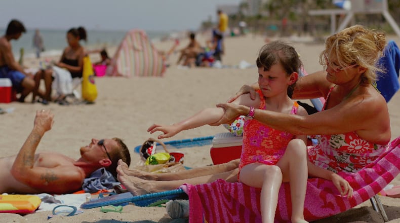 Sharon Doyle puts sunscreen on the arm of 9-year-old Savannah Stidham as they visit the beach June 20, 2006 in Fort Lauderdale, Florida.