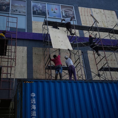 Workers board up shop windows ahead of Hurricane Melissa's forecast arrival in Kingston, Jamaica, Sunday, Oct. 26, 2025. (AP Photo/Matias Delacroix)