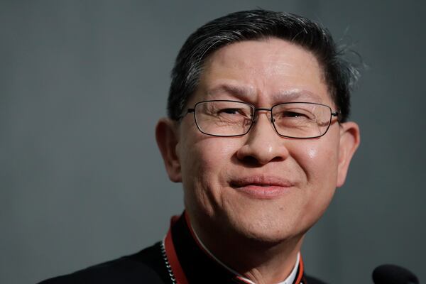 FILE - Cardinal Luis Tagle smiles as he listens reporters questions during a press conference on the Synod at the Vatican, Tuesday, Oct. 23, 2018. (AP Photo/Alessandra Tarantino, File)