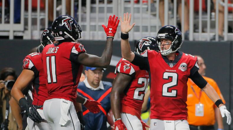Atlanta Falcons wide receiver Julio Jones (left) and Atlanta Falcons quarterback Matt Ryan high five after Atlanta Falcons running back Tevin Coleman scored a first half TD.  Atlanta Falcons vs Green Bay Packers.   The Falcons opened the roof for the Falcons season opener at Mecedes-Benz Stadium.   BOB ANDRES  /BANDRES@AJC.COM