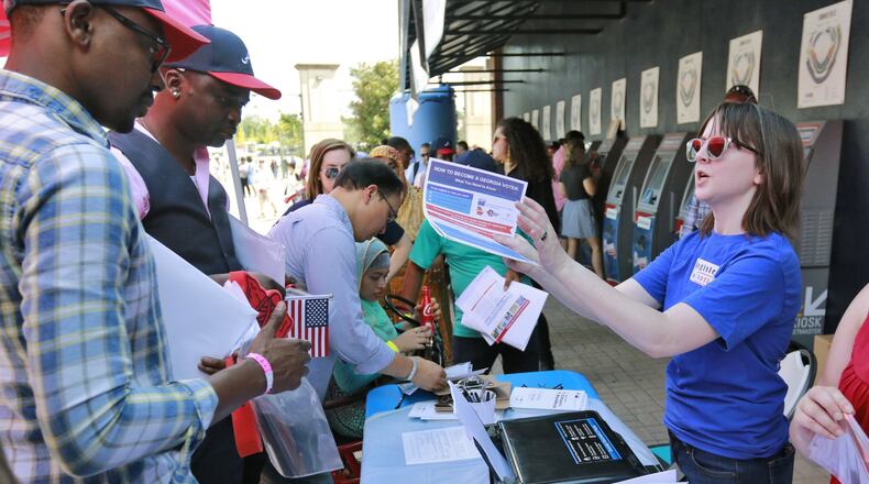 September 16, 2016 - Atlanta - Stephanie Ali (right), with New American Pathways, registers newly sworn-in citizens to vote. BOB ANDRES /BANDRES@AJC.COM