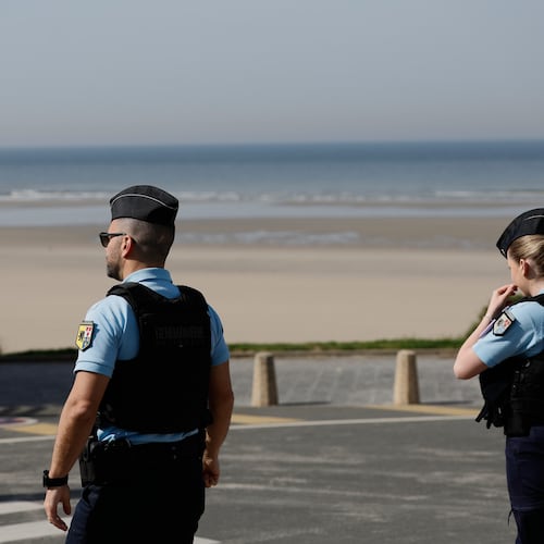 Policemen stand guard after a migrant taxi-boat accident, in Equihen-Plage, northern France, Thursday, April 9, 2026. (AP Photo/Jean-Francois Badias)