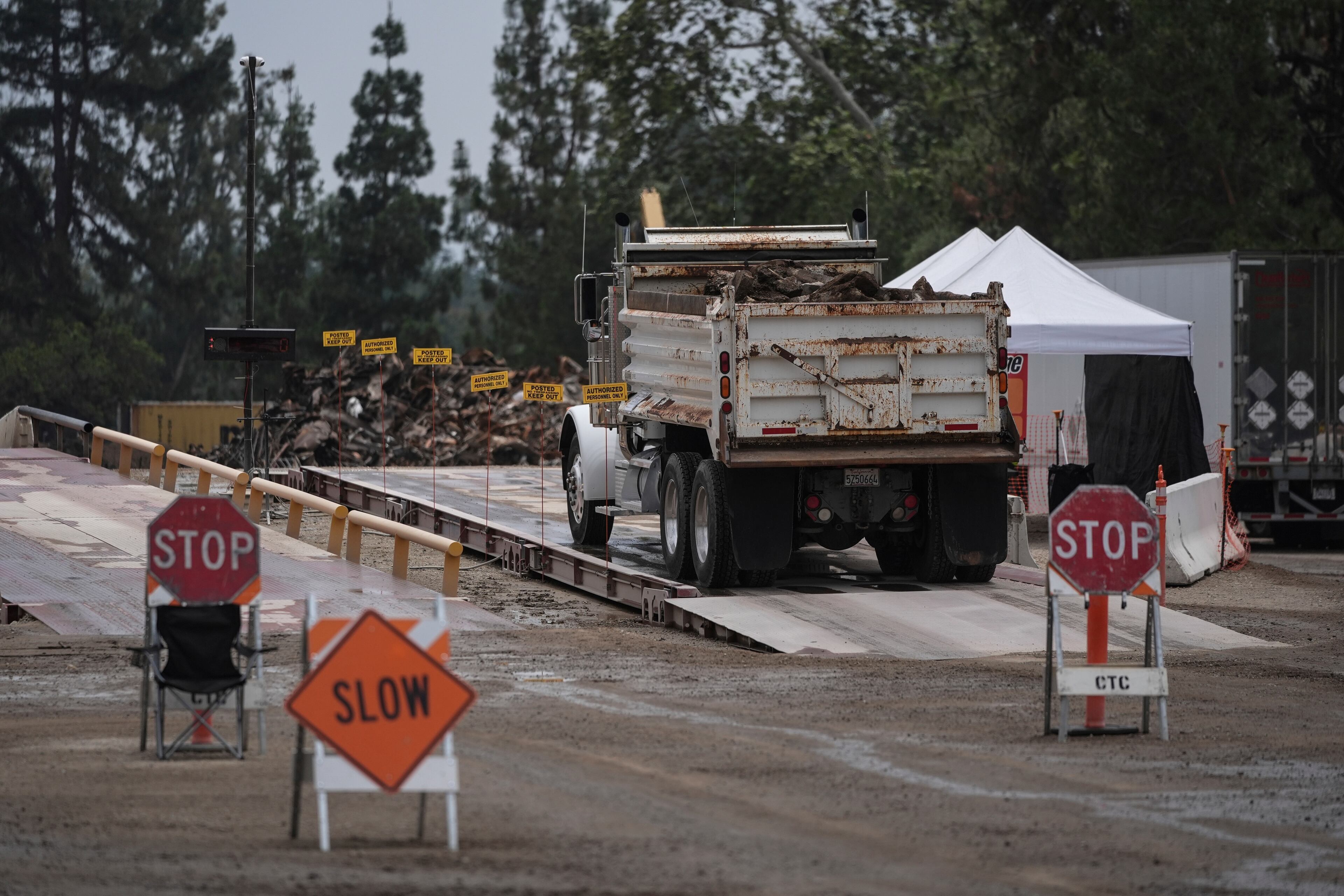 A dump truck carrying debris removed from January wildfires arrives at a recycling facility set up on a golf course in Altadena, Calif., Wednesday, June 4, 2025. (AP Photo/Jae C. Hong)
