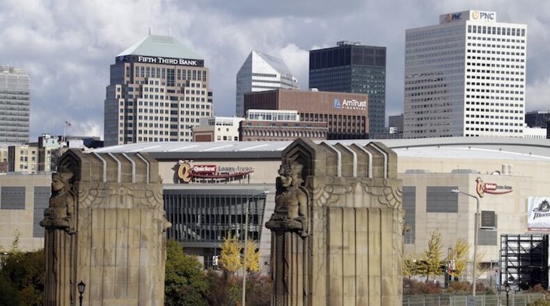 This Nov. 8, 2013, file photo shows Cleveland’s skyline and the venue of the 2016 Republican National Convention, Quicken Loans Arena, framed by the Guardians of Traffic sculptures at the east end of the Hope Memorial Bridge in Cleveland. Donald Trump's effort to unite a splintered Republican Party around his candidacy is about to take center stage in a city that is itself deeply fractured. (AP Photo/Mark Duncan, File)