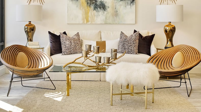 The vignette captures the spirit and design aesthetic of Huff Harrington Home: A neutral backdrop that comes to life with a little sparkle from the antique French chandelier, a bold abstract painting by Melissa Payne Baker and matching starburst mirrors. A classic white linen sofa and a 1970s brass coffee table from Paris anchor the space, along with two contemporary wood frame chairs. A Mongolian lamb’s wool bench adds an extra layer of texture. Contributed by Emily Followill