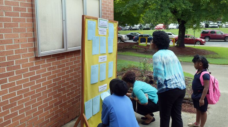 Students and parents arrive on the first day of classes at Woodridge Elementary School in Stone Mountain in 2016. Some parents begin angling to get their student assigned to different teachers after they find out which class the young person has been put into, causing headaches for teachers and principals. KENT D. JOHNSON/kdjohnson@ajc.com