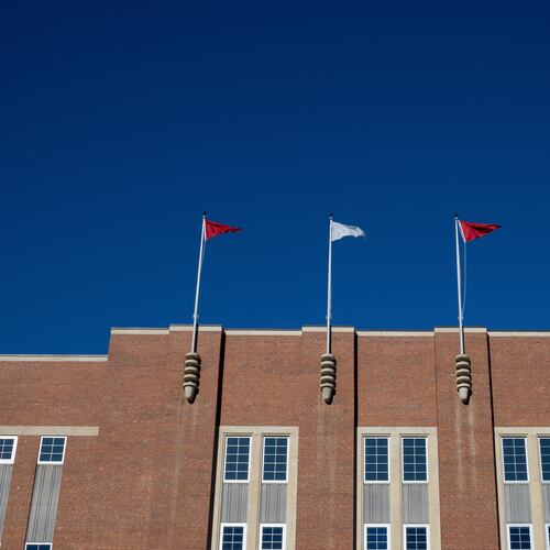 FILE - Flags fly above at the Reynolds Coliseum on the campuse of North Carolina State University, Feb. 19, 2022, in Raleigh, N.C. (AP Photo/Kara Durrette, File)