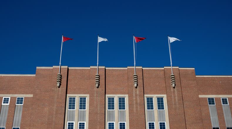 FILE - Flags fly above at the Reynolds Coliseum on the campuse of North Carolina State University, Feb. 19, 2022, in Raleigh, N.C. (AP Photo/Kara Durrette, File)