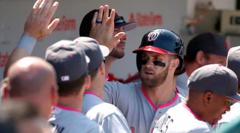 Washington Nationals' Bryce Harper celebrates with teammates after scoring on a double by Ryan Zimmerman during the third inning of a baseball game against the Chicago Cubs, Sunday, May 8, 2016, in Chicago. (AP Photo/Nam Y. Huh)