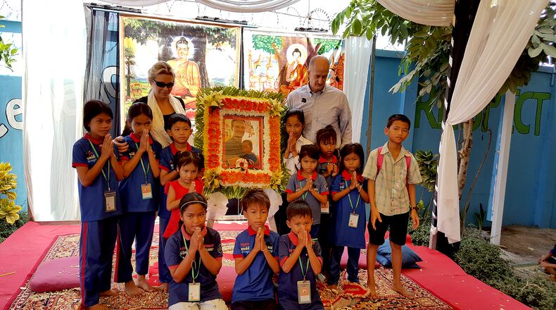 Cammie and John Rice stand with the Cambodia children their family sponsors following her son’s death. The Rice family founded the Rice Academy in Cambodia. (Family photo)