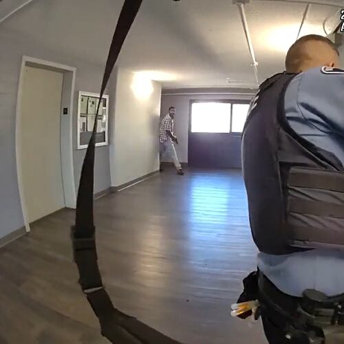 This image made from body camera video provided by the Minneapolis Police Department of a Wednesday, Sept. 2, 2026, shooting shows Minneapolis police Officer Joseph Michnowski looking down an apartment hallway as Carlton Johnson emerges with a handgun. (City of Minneapolis via AP)