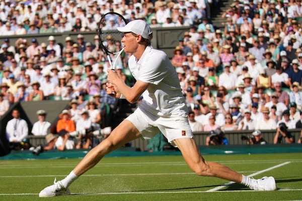 Jannik Sinner of Italy slides as he plays a return to Novak Djorkovic of Serbia during the men's semifinal singles match at the Wimbledon Tennis Championships in London, Friday, July 11, 2025.(AP Photo/Joanna Chan)