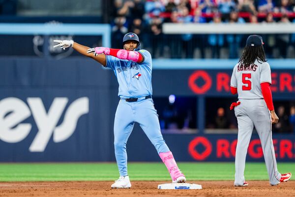 Toronto Blue Jays first base Vladimir Guerrero Jr. (27) celebrates hitting a double during the third inning of MLB baseball action against the Washington Nationals, in Toronto, Monday, March 31, 2025. (Thomas Skrlj/The Canadian Press via AP)