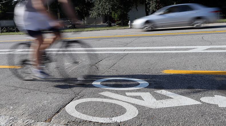 A cyclist makes his way up Tenth Street using the new cycle track that was recently added to the section of street between Monroe Drive and Charles Allen Drive along side Piedmont Park.
