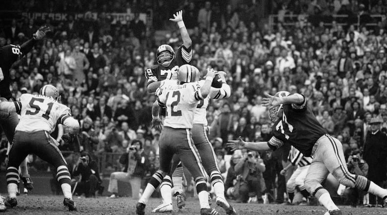 FILE - Dallas Cowboys quarterback Roger Staubach rears back to pass 22 yards to Ron Sellers (88) on a third down play late in the second quarter, Dec. 31, 1972. (AP Photo)