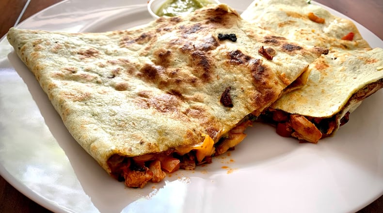 Buenos Dias Cafe's red chicken mole quesadilla is packed with veggies. Henri Hollis/henri.hollis@ajc.com