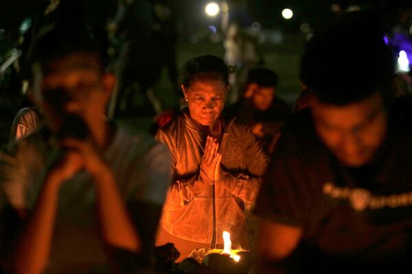 A woman prays during a vigil for the late Pope Francis in Dili, East Timor, Monday, April 21, 2025. (AP Photo/Lorenio L.Pereira)