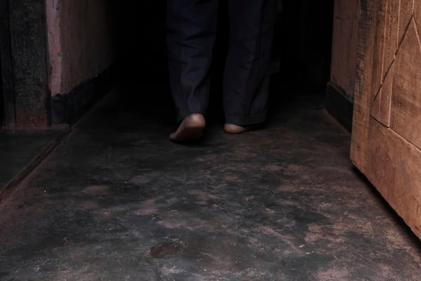 Simon Tigawalana walks into his house with some clay-based earthen floors by EarthEnable on May 16, 2025, in Jinja, Uganda. (AP Photo/Hajarah Nalwadda)