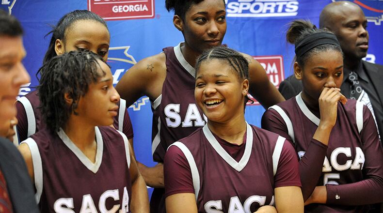 MARCH 8, 2014 MACON Southwest Atlanta Christian Warrior players Southwest Atlanta Christian Warriors Marquita Daniels #10, Southwest Atlanta Christian Warriors Tiamya Butler #14 and Southwest Atlanta Christian Warriors Keimeshia Walker #5 celebrate during the awards ceremony after the game. Coverage of the Class A Private girls basketball championship between the Southwest Atlanta Christian Warriors and Holy Innocents' Golden Bears at the Macon Coliseum Saturday, March 8, 2014. Southwest Atlanta Christian won, 57-52 over the Holy Innocents' Golden Bears. KENT D. JOHNSON / KDJOHNSON@AJC.COM Southwest Atlanta Christian players Marquita Daniels (10), Tiamya Butler (14) and Keimeshia Walker (5) celebrate the Class A Private title win over Holy Innocents Saturday, March 8, 2014, in Macon. (Kent D. Johnson / AJC)