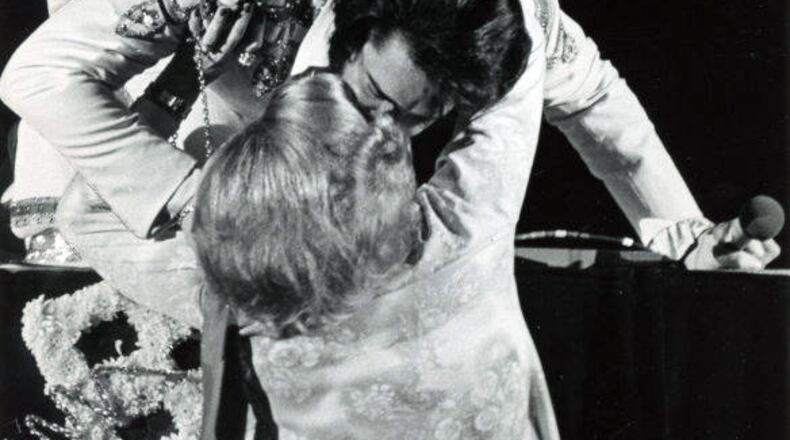 Elvis Presley bends down from stage to kiss a fan at the Omni during his three-day concert in Atlanta in 1976.Photo by Bud Skinner