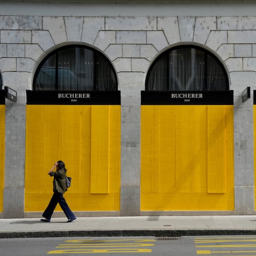 Pedestrians walk past the boarded-up windows of a shop, ahead of expected protests for the G7 summit, in Geneva, Switzerland, Tuesday, June 9, 2026. (AP Photo/Baz Ratner)