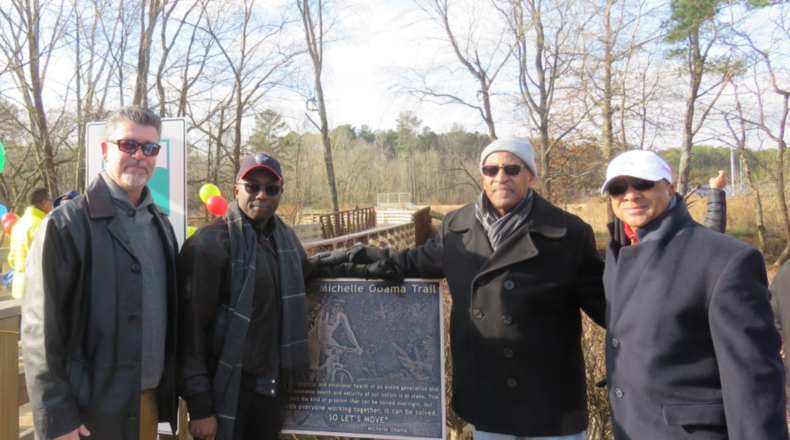 Rich Alvarez of First Tee of Atlanta, DeKalb Commissioner Larry Johnson, DeKalb County Recreation interim director Marvin Billups and Marvin Hightower of First Tee Atlanta pose next to a sign at the Michelle Obama Trail. (Photo courtesy of DeKalb County)