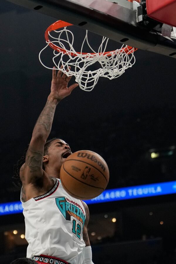 Memphis Grizzlies guard Ja Morant (12) dunks the ball during the first half of an NBA play-in tournament basketball game against the Dallas Mavericks, Friday, April 18, 2025, in Memphis, Tenn. (AP Photo/George Walker IV)
