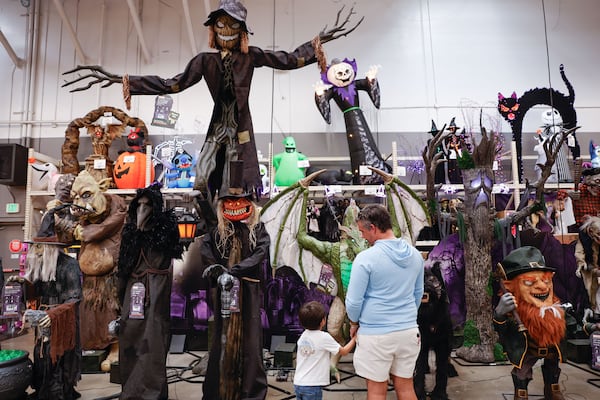 John Bradshaw and his son Jack, 5, look at the Halloween decorations at Home Depot in Vinings on Monday, Sept. 29, 2025. The display features "Worricrow," (center), a 15-foot-high scarecrow. (Natrice Miller/AJC)