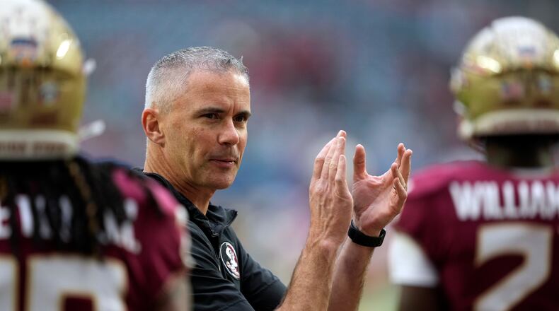 FILE -  Florida State head coach Mike Norvell claps as his players warm up for the Orange Bowl NCAA college football game against Georgia, Saturday, Dec. 30, 2023, in Miami Gardens, Fla. Norvell, like most every other team in the Atlantic Coast Conference, has spent the spring handling change.  He hopes it can lead to another league title and a spot in the 12-team College Football Playoff.  (AP Photo/Rebecca Blackwell, File)