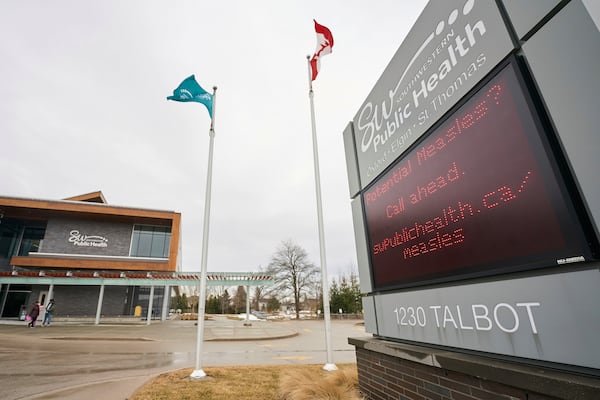 A sign outside Southwestern Public Health in St. Thomas, Ontario, Canada, on Tuesday, March 4, 2025, warns residents to call ahead before visiting a doctor or hospital if they think they have the measles. (Geoff Robins/The Canadian Press via AP)