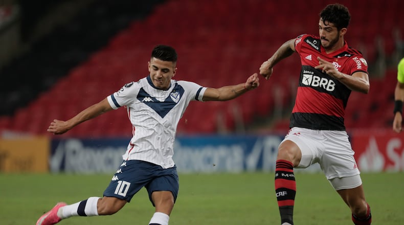 Thiago Almada of Argentina's Velez Sarsfield (left) and Gustavo Henrique of Brazil's Flamengo battle for the ball during a Copa Libertadores soccer match Thursday, May 27, 2021, in Rio de Janeiro, Brazil. (Antonio Lacerda/AP)