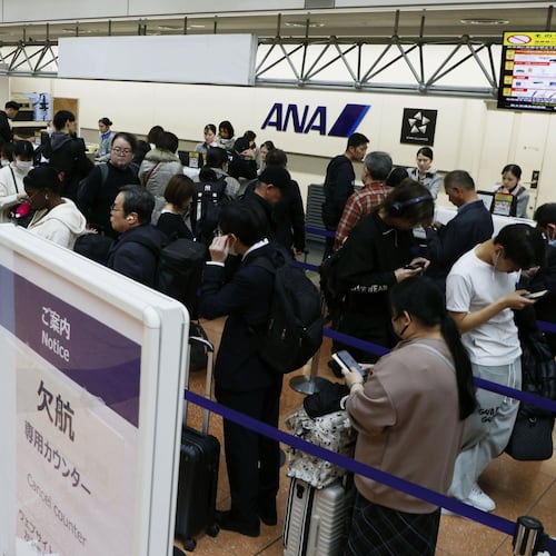 Passengers wait in line at All Nippon Airways' counter at Haneda airport in Tokyo Saturday, Nov. 29, 2025. A sign, right, reads " Flight cancellation counter." (Takahiko Kanbara/Kyodo News via AP)