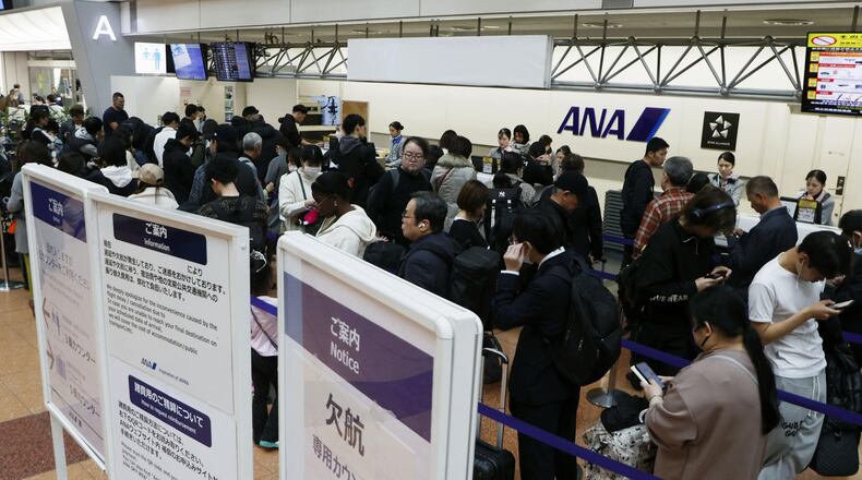 Passengers wait in line at All Nippon Airways' counter at Haneda airport in Tokyo Saturday, Nov. 29, 2025. A sign, right, reads " Flight cancellation counter." (Takahiko Kanbara/Kyodo News via AP)