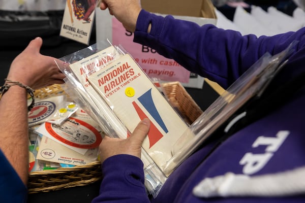 People went through vintage airline time tables at a Delta Flight Museum Surplus Sale in October 2025. A changing variety of goods is offered at each sale. The next one is Friday. (Arvin Temkar/AJC)