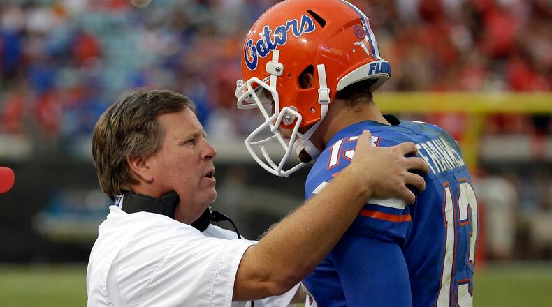 Florida head coach Jim McElwain talks with quarterback Feleipe Franks (13) on the sideline in the second half of an NCAA college football game against Georgia, Saturday, Oct. 28, 2017, in Jacksonville, Fla. Georgia won 42-7. (AP Photo/John Raoux)