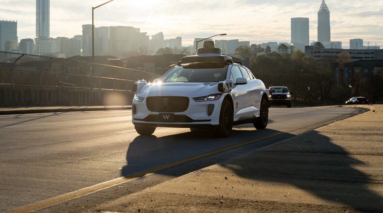 A Waymo self-driving taxi travels down 17th Street in Atlanta, Thursday, Dec. 11, 2025 (Ben Hendren for the AJC)