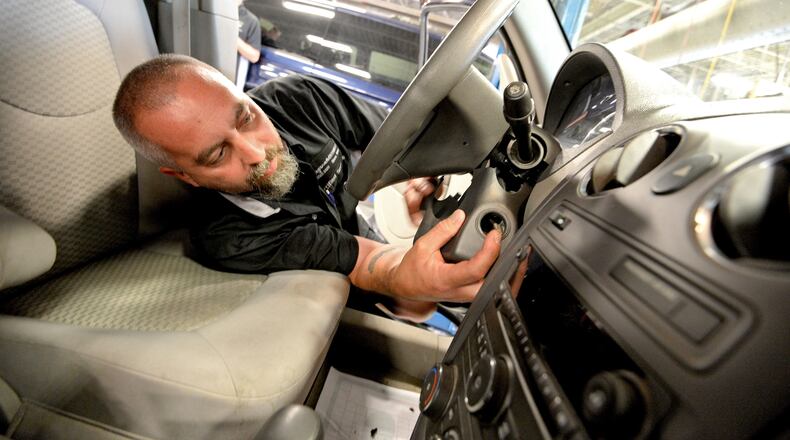 Auto technician Billy Morgan works on installing a new ignition switch at Fitzgerald Auto Mall in 2014.