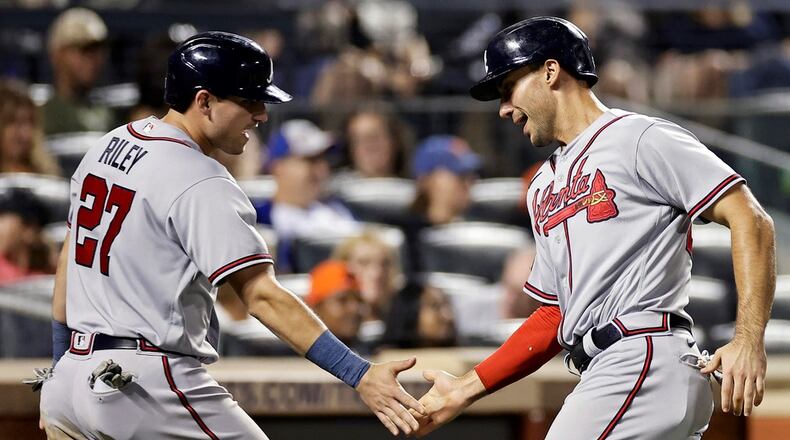 Atlanta Braves' Austin Riley (27) and Matt Olson, right, celebrate after scoring against the New York Mets during the eighth inning in the second baseball game of a doubleheader on Saturday, Aug. 12, 2023, in New York. (AP Photo/Adam Hunger)