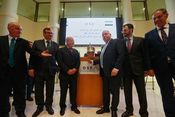 Syrian Finance Minister Mohammed Yisr Barnieh, center right, rings the opening bell at the Damascus Securities Exchange in Damascus, Syria, Monday, June 2, 2025. (AP Photo/Omar Sanadiki)