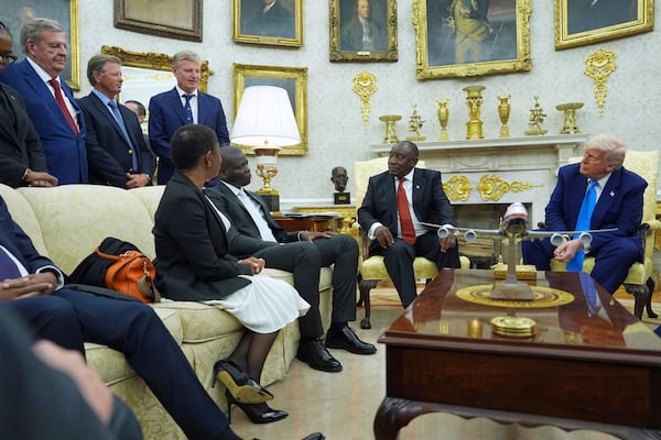 President Donald Trump meets South African President Cyril Ramaphosa in the Oval Office of the White House, Wednesday, May 21, 2025, in Washington, as Johann Rupert, looks on, upper left. (AP Photo/Evan Vucci)