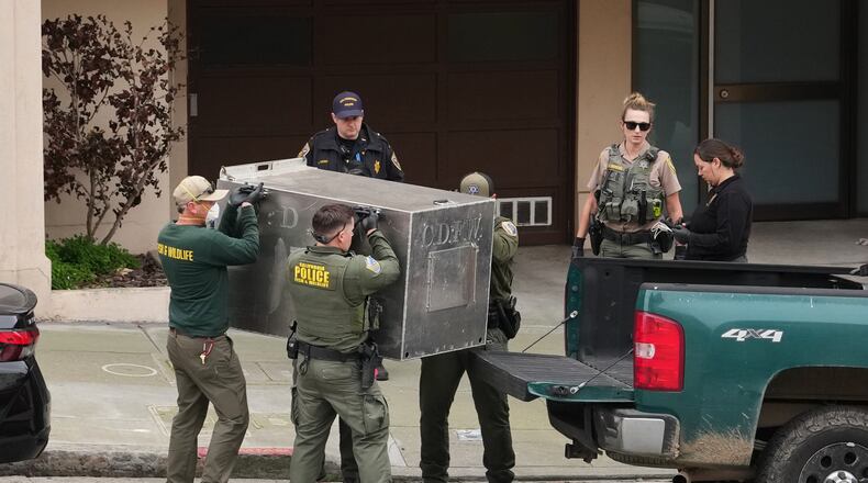California Fish and Wildlife officials carry a tranquilized mountain lion in a cage after it was captured on Tuesday, Jan. 27, 2026, in San Francisco. (AP Photo/Andy Bao)