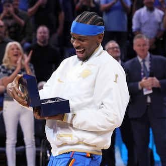 Oklahoma City Thunder guard Shai Gilgeous-Alexander looks at his championship ring during a ceremony before an NBA basketball game against the Houston Rockets Tuesday, Oct. 21, 2025, in Oklahoma City. (AP Photo/Nate Billings)