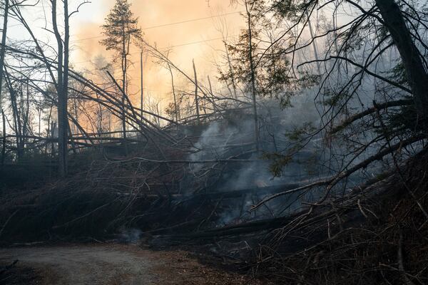 Smoldering remains of Hurricane Helene debris that caught fire are seen during the Black Cove Fire Wednesday, March 26, 2025, in Saluda, N.C. (AP Photo/Allison Joyce)