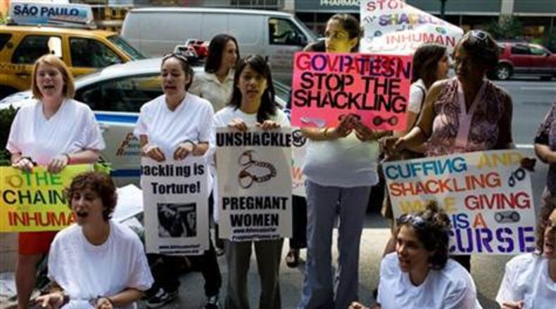 Protesters call on the New York governor to sign an anti-shackling bill. AP photo
