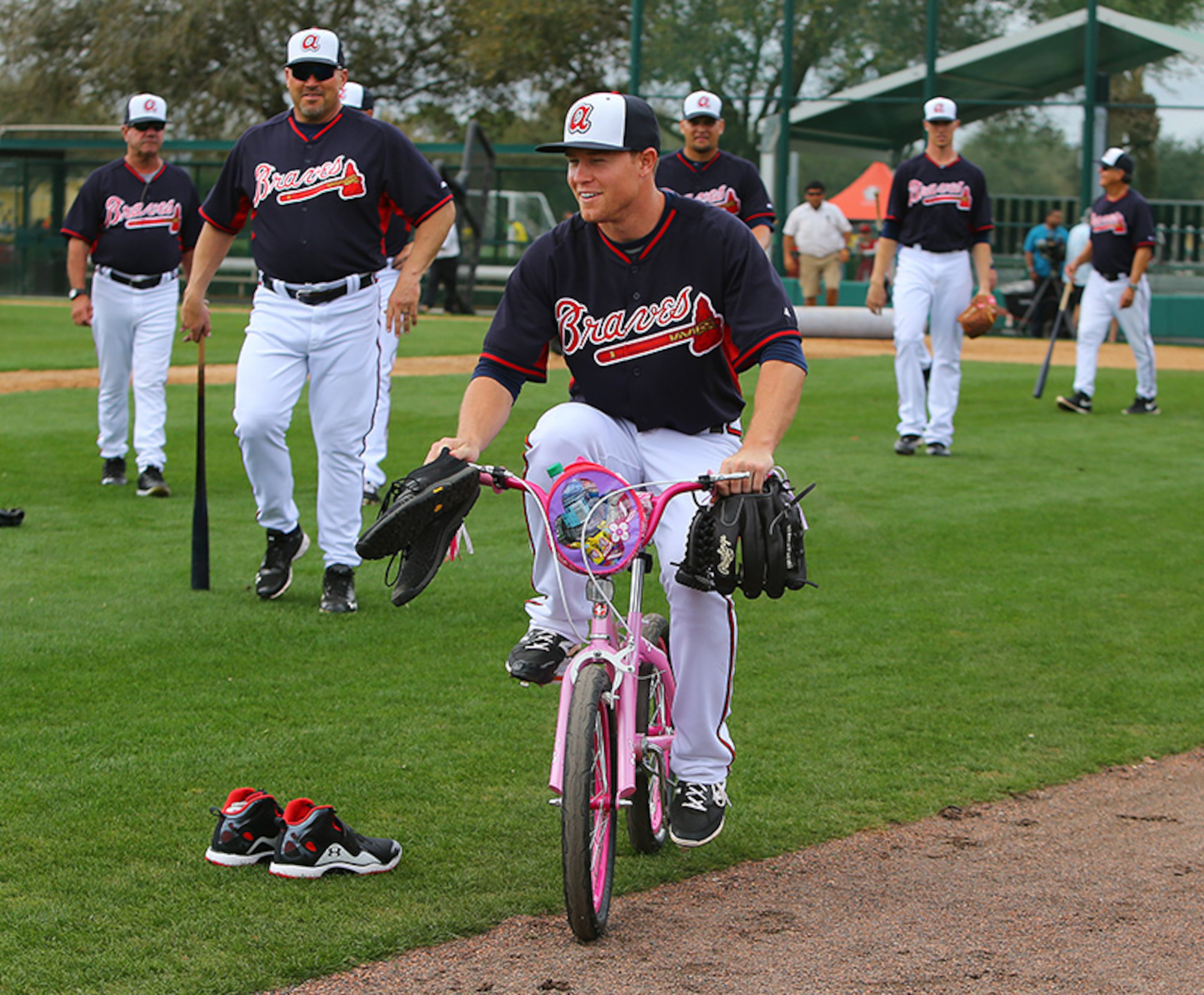 Braves manager Fredi Gonzalez (left) looks on as pitcher Shae Simmons rides a girls bicycle at spring training in 2014.