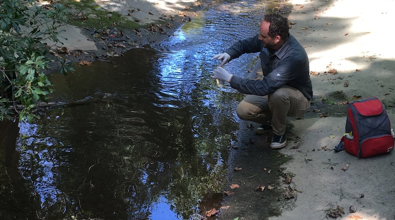 Mike Meyer, program director of Chattahoochee Riverkeeper Neighborhood Water Watch program, takes samples from Proctor Creek. With the help of citizen water monitors, the group has been tracking contamination levels in the creek for almost a decade. Photo Credit: Nedra Rhone
